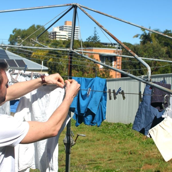 Image of a man hanging up washing with stainless steel clothes pegs